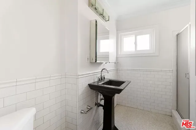 a bathroom with a sink a mirror and a shower