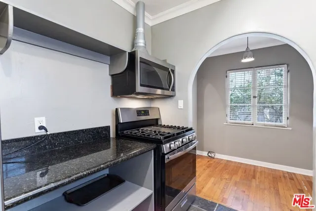a kitchen with stainless steel appliances granite countertop a stove and a microwave