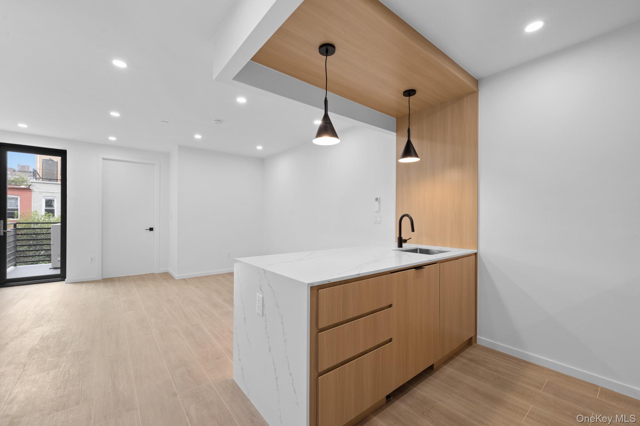 366 Harman Street, Unit 3R Brooklyn, NY 11237 - Photo 12 of 19 Kitchen featuring recessed lighting, light stone countertops, a peninsula, light wood-style flooring, and pendant lighting