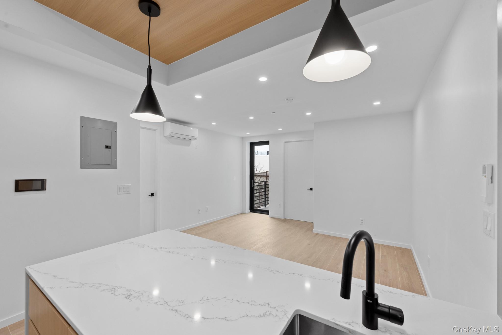 366 Harman Street, Unit 3R Brooklyn, NY 11237 - Photo 15 of 19 Kitchen featuring light stone countertops, recessed lighting, electric panel, hanging light fixtures, and light wood-style flooring