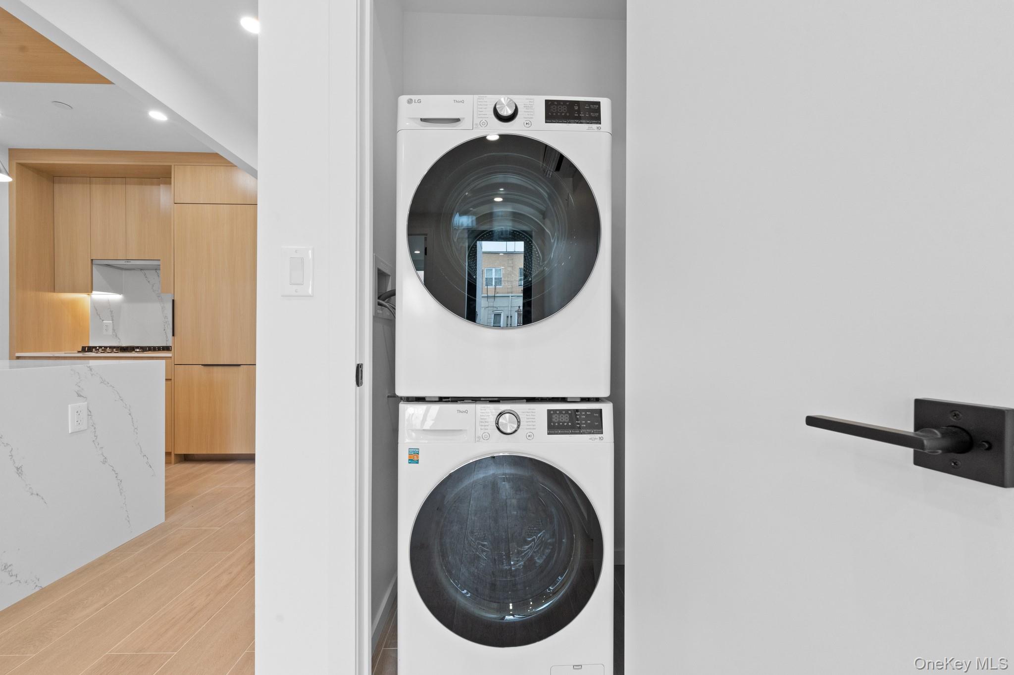 366 Harman Street, Unit 3R Brooklyn, NY 11237 - Photo 17 of 19 Washroom with stacked washing machine and dryer and wood tiled floors