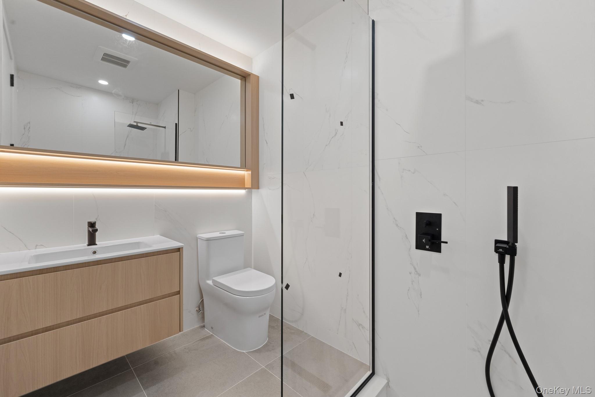 366 Harman Street, Unit 3R Brooklyn, NY 11237 - Photo 19 of 19 Bathroom with vanity, dark tile patterned floors, and a marble finish shower