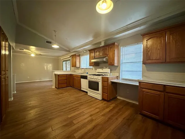 a kitchen with stainless steel appliances granite countertop a stove a sink and a microwave