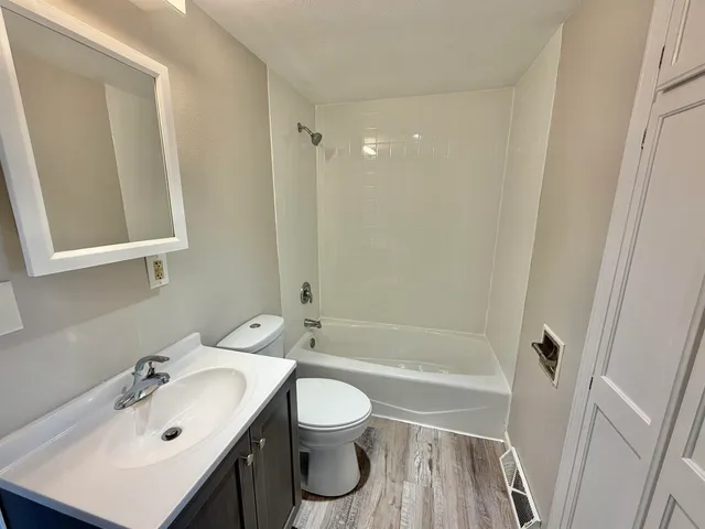 a view of a small space with wooden floor and closet