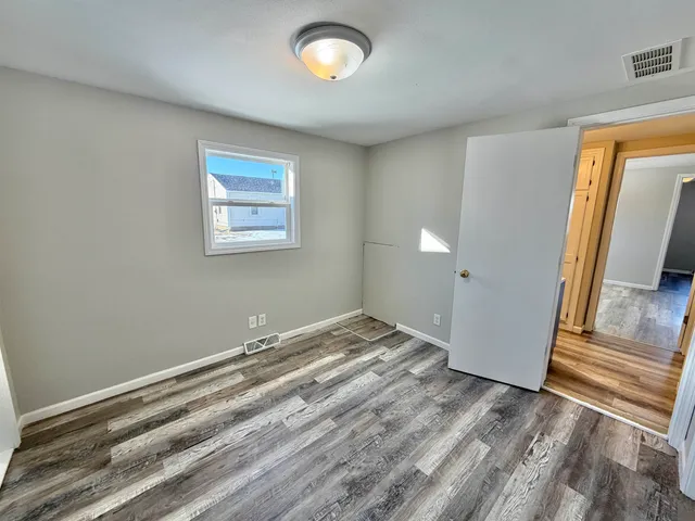 a view of empty room with wooden floor