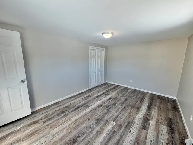 a view of a room with wooden floor and window