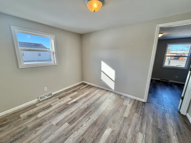 a view of a room with wooden floor and window