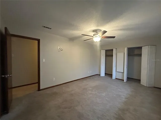 an empty room with fan and entrance