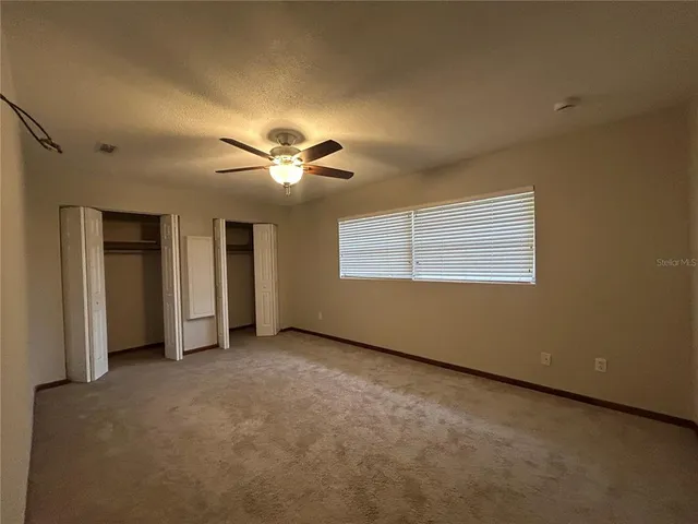 a view of an empty room with a ceiling fan