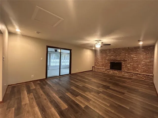 an empty room with wooden floor and fireplace