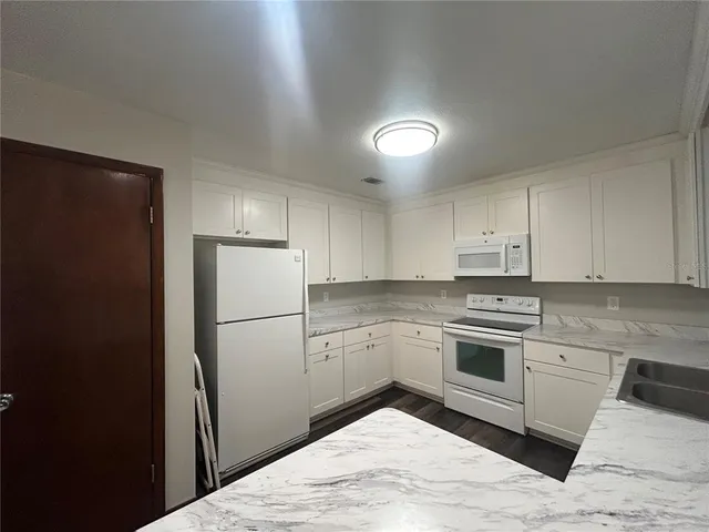 a kitchen with a refrigerator and a stove top oven