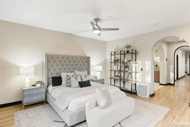 a bedroom with a large bed and a chandelier