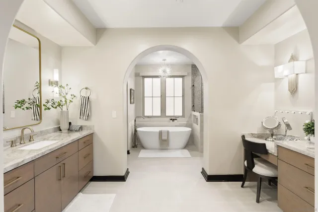 a spacious bathroom with a double vanity sink mirror and bathtub