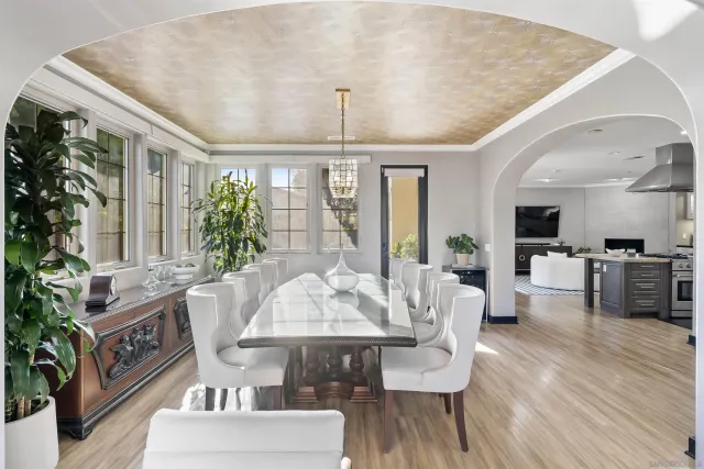 a living room with furniture dining table a large window and potted plants