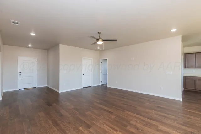 a view of an empty room with wooden floor