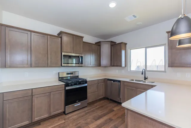 a kitchen with stainless steel appliances granite countertop a sink stove and microwave