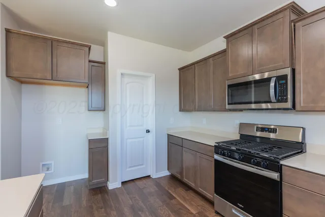 a kitchen with stainless steel appliances and wooden cabinets