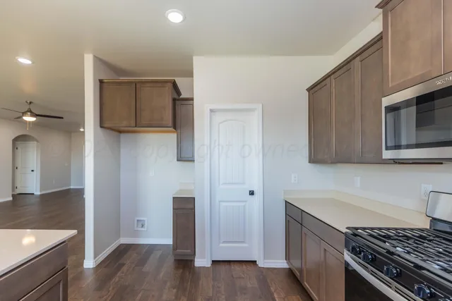 a kitchen with a refrigerator and a stove top oven