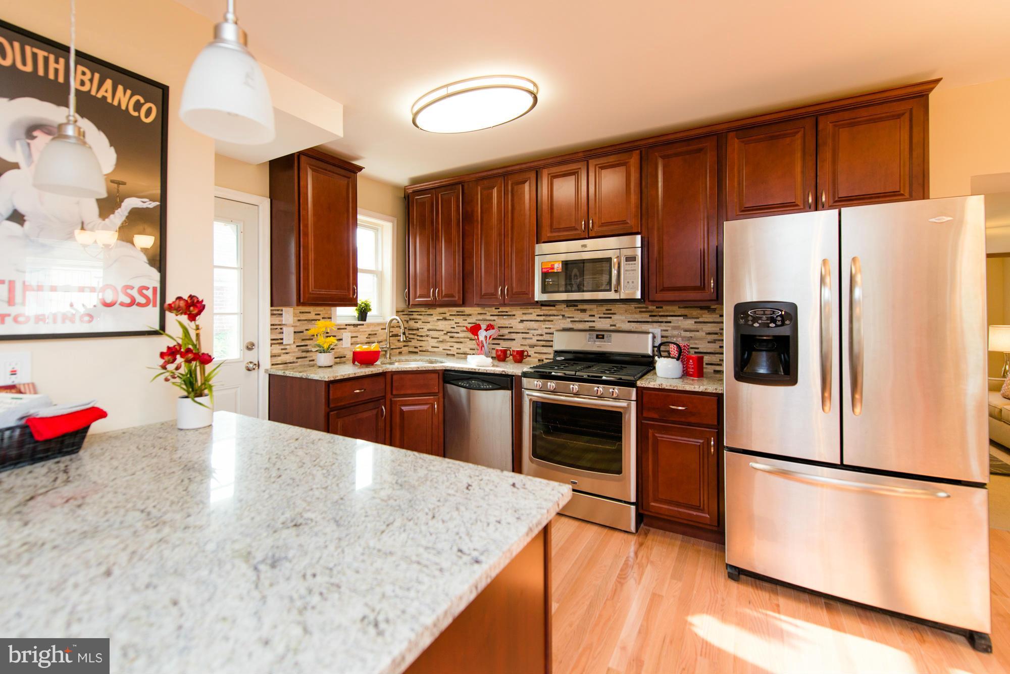 6812 Dunhill Road Baltimore, MD 21222 - Photo 8 of 30 a kitchen with stainless steel appliances granite countertop a refrigerator sink stove microwave and cabinets