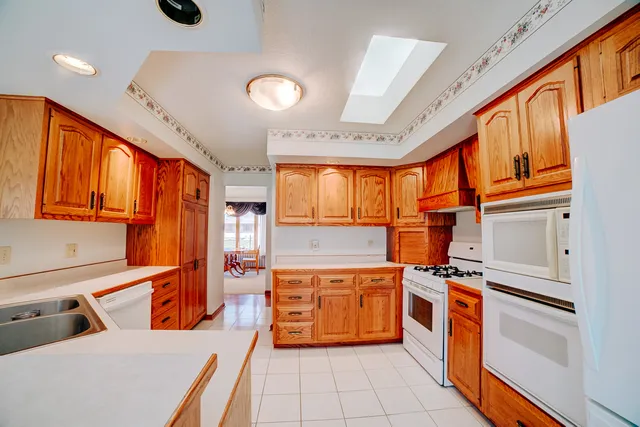 a kitchen that has a lot of white cabinets and stainless steel appliances