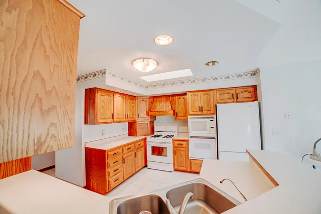 a large white kitchen with a large window