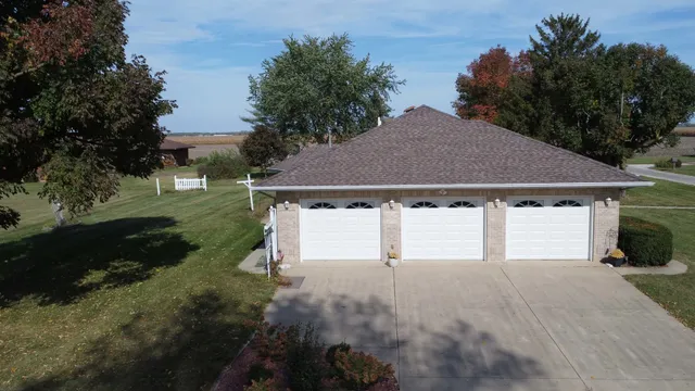 a front view of house with yard and trees in the background