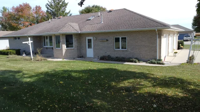 a view of a house with a yard and sitting area