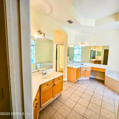a large bathroom with a large tub sink and mirror