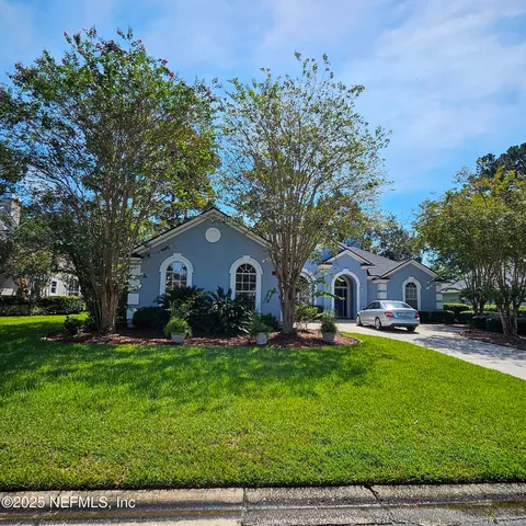 a front view of a house with a yard and trees