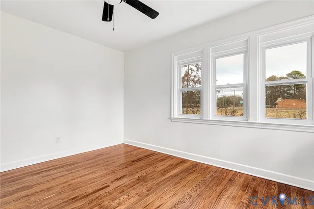 a view of an empty room with wooden floor