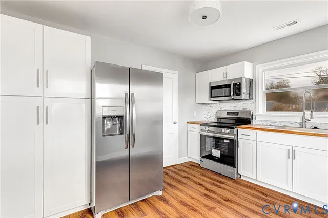 a kitchen with kitchen island a counter top space appliances and a sink