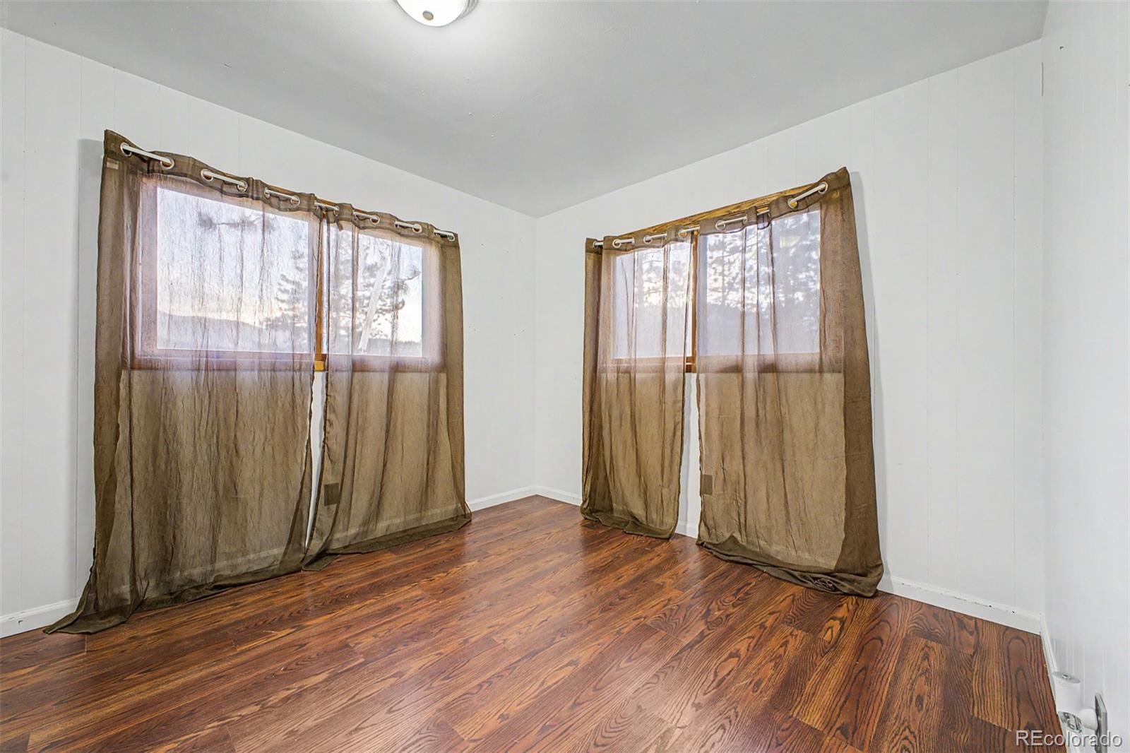 145 Bailey Drive Bailey, CO 80421 - Photo 23 of 31 an empty room with wooden floor and windows
