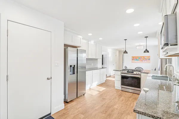 a kitchen with stainless steel appliances granite countertop a refrigerator a stove and a sink