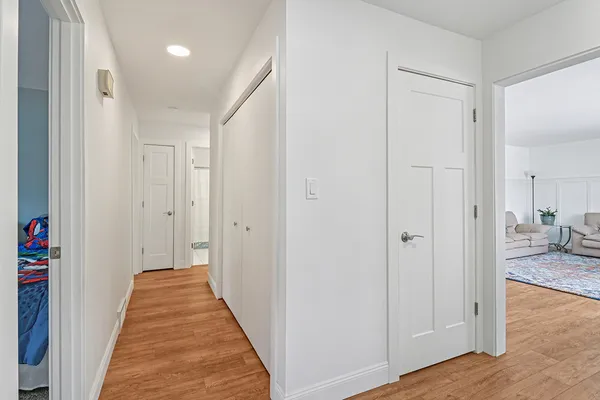 a view of a hallway with wooden floor and closet
