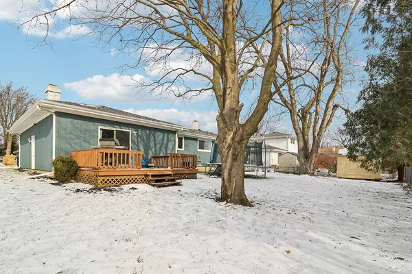 a front view of a house with a yard covered in snow