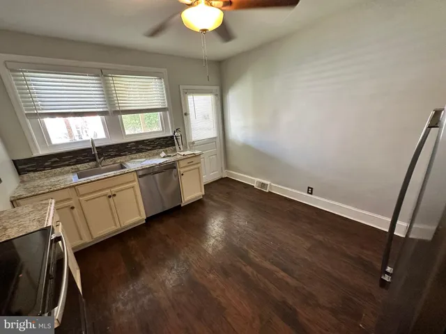 a view of a kitchen with a sink dishwasher and wooden floor