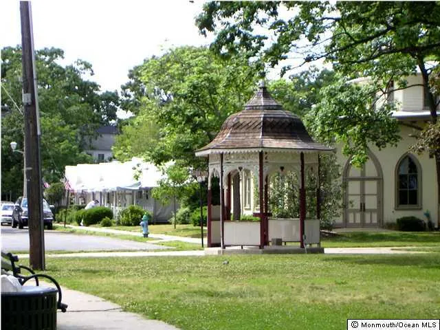 a view of a white house with a big yard and large trees