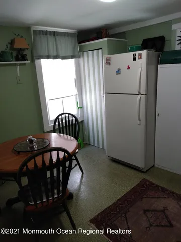 a view of a furniture in kitchen and an empty room