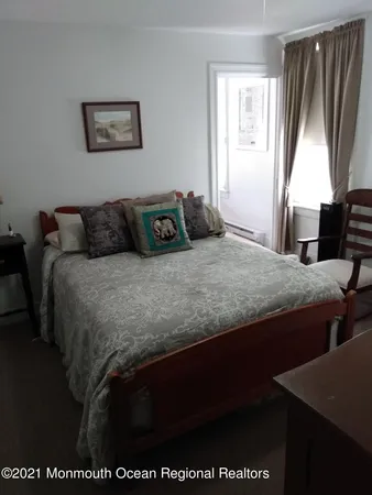 a bedroom with a bed next to a window