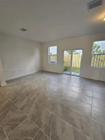 a view of an empty room with a fireplace and a window