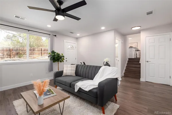 a living room with furniture and wooden floor