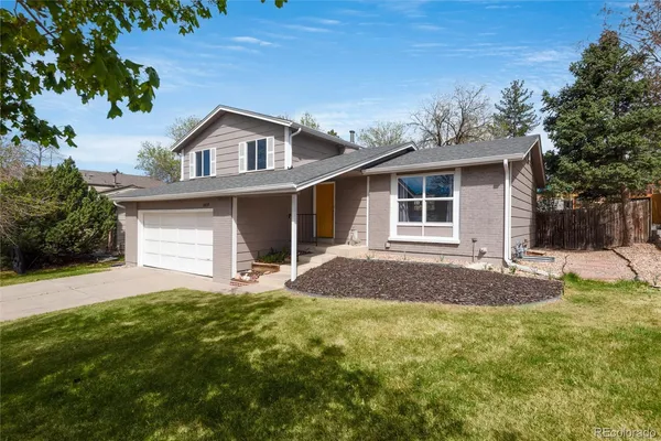 a front view of a house with a garden and yard
