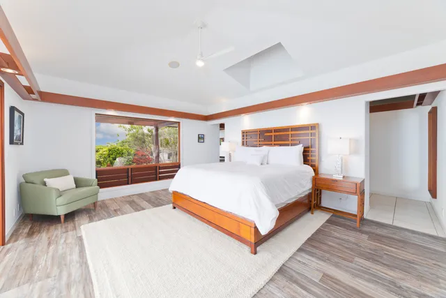 a living room with wooden floor and a large window