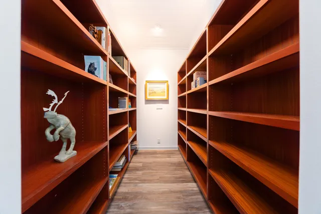 a bedroom with a bed and large windows