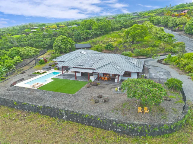 an aerial view of residential houses with outdoor space and trees