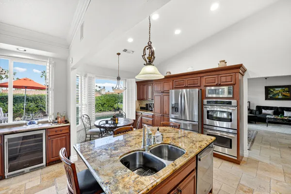 a kitchen with stainless steel appliances granite countertop a stove a refrigerator a table and chairs