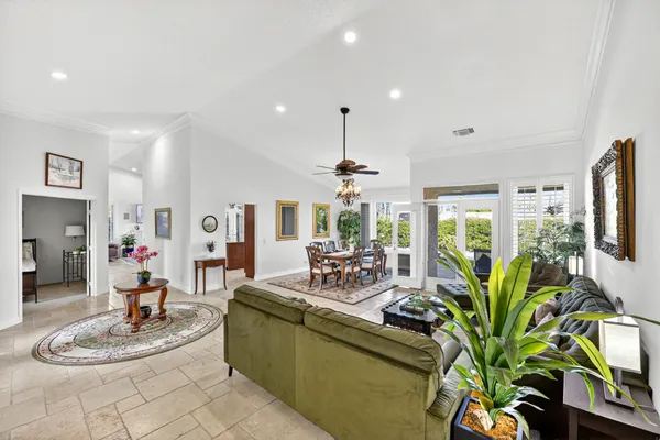 a dining room with furniture a large window and a chandelier