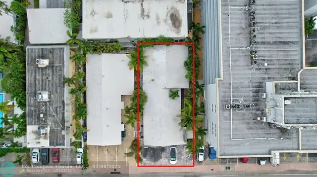 an aerial view of residential houses with outdoor space and trees
