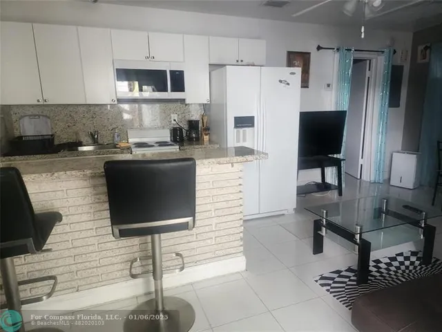 a kitchen with stainless steel appliances a refrigerator sink and cabinets