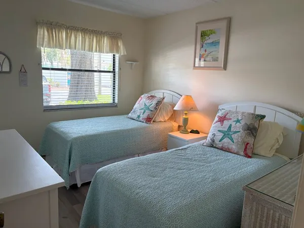 a bedroom with two beds and a window